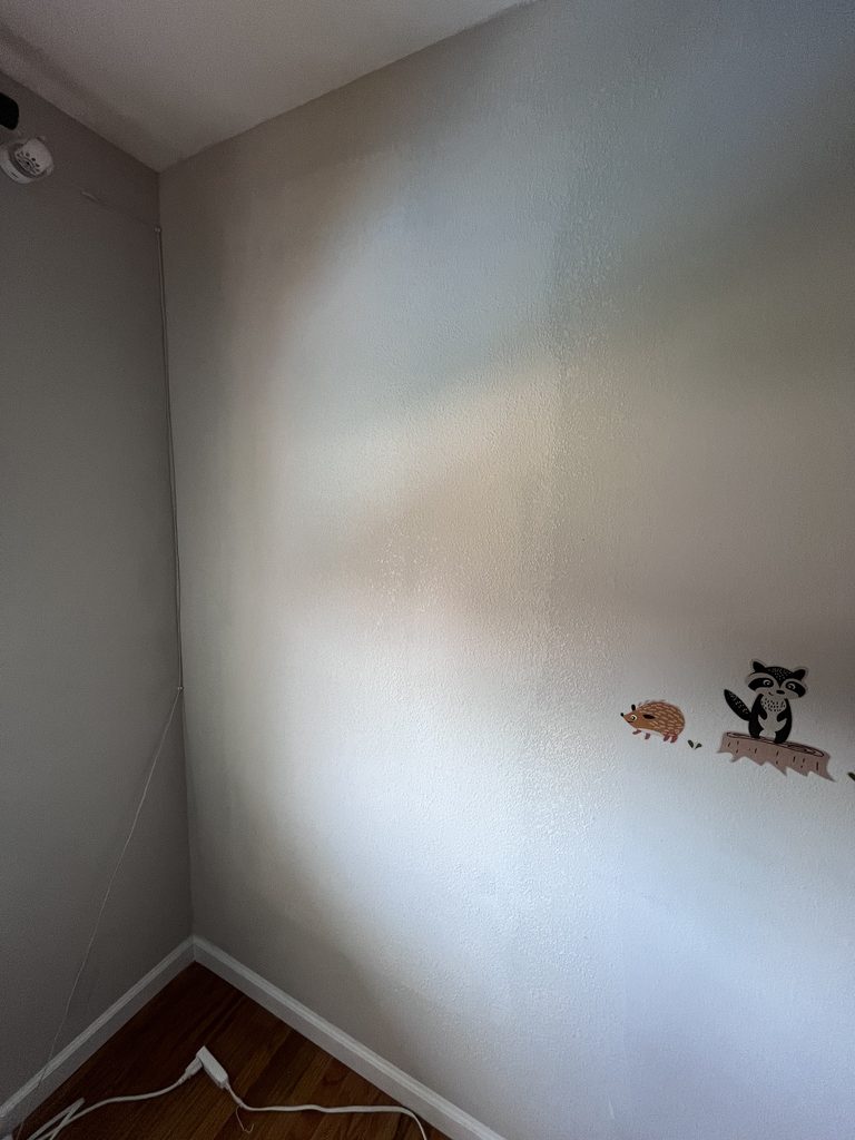 The same bedroom wall after taping, compound and texture matching, the access cut no longer visible